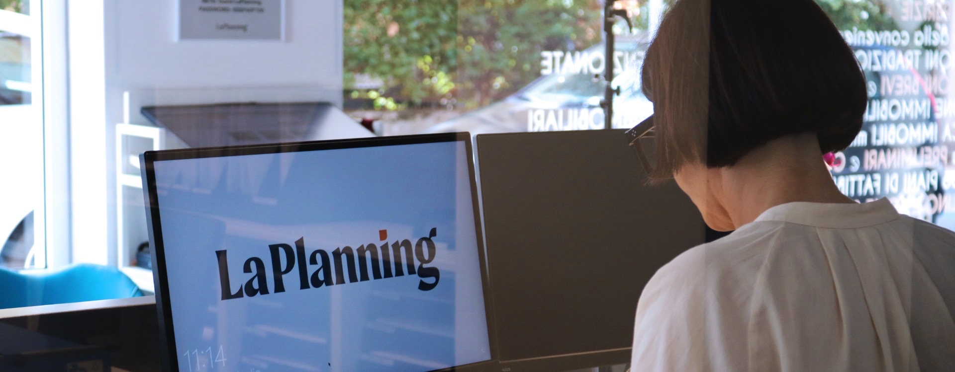 La sede LaPlanning vista dalla vetrina, con il logo sullo schermo